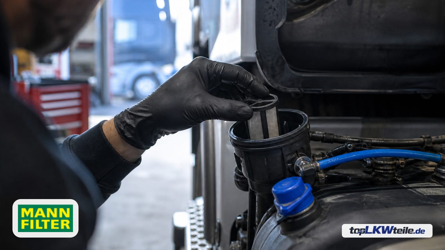 Mechaniker mit Handschuhen setzt einen kleinen zylindrischen MANN-FILTER Filter für Harnstofflösung (feines Edelstahlgewebe, schwarzer Kunststoffrahmen) in das AdBlue-Modul eines Lkw ein.