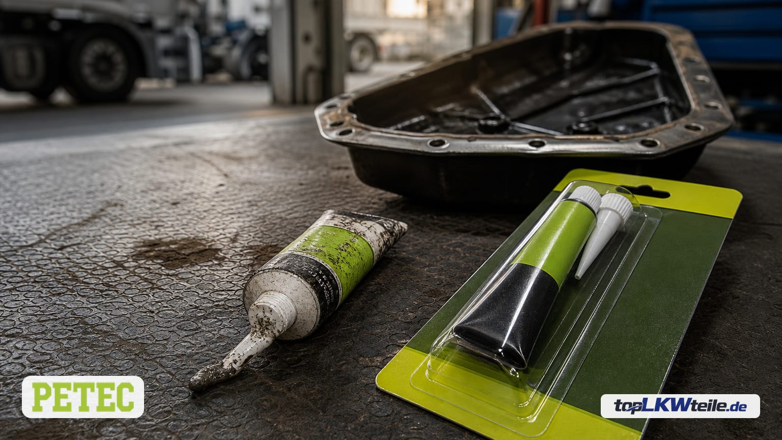 Neue PETEC Dichtung, Automatikgetriebe im grünen Blister neben einer verbrauchten Tube auf einer Werkstattmatte; Getriebeölwanne unscharf im Hintergrund.